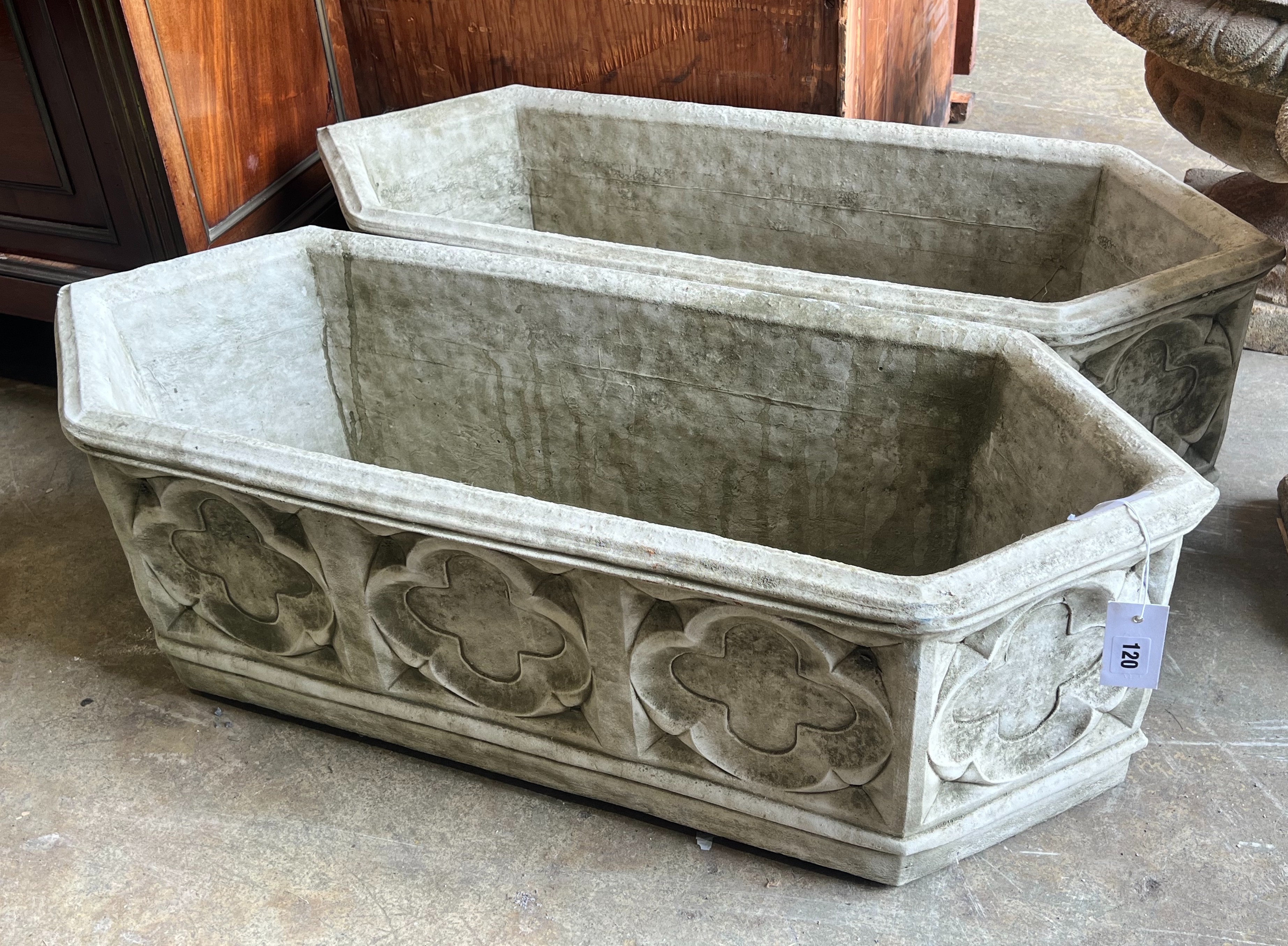 A pair of Gothic style reconstituted stone garden planters of elongated hexagonal form, width 88cm depth 33cm height 28cm